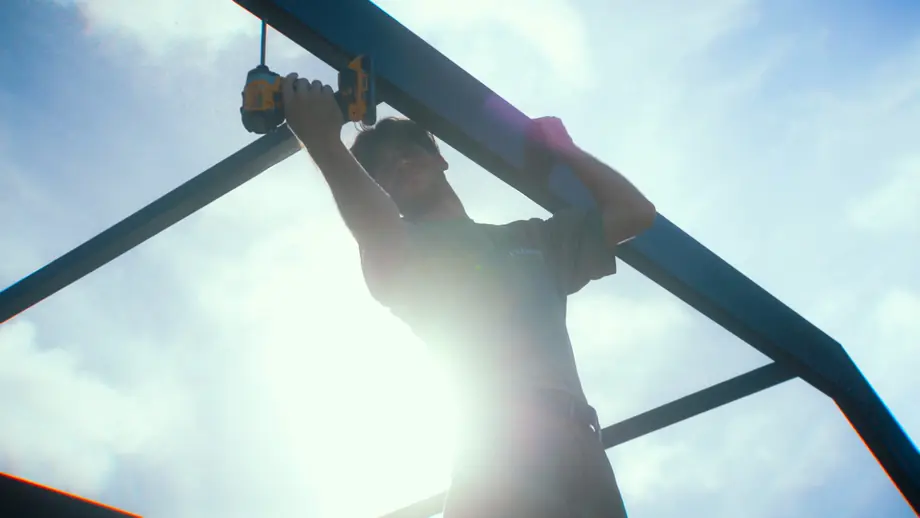 Technician repairing a damaged section of a pool cage enclosure